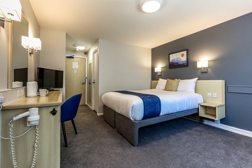 Bedroom wit double bed, TV, desk, tea and coffee making facilities and hairdryer