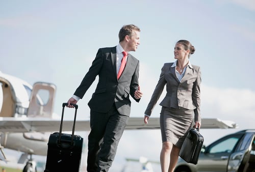 business-couple-travelling-with-bags-at-airport