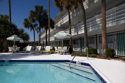 A pool surrounded by palm trees and lounge chairs at The Teale Siesta Lago in Kissimmee, FL, 34746