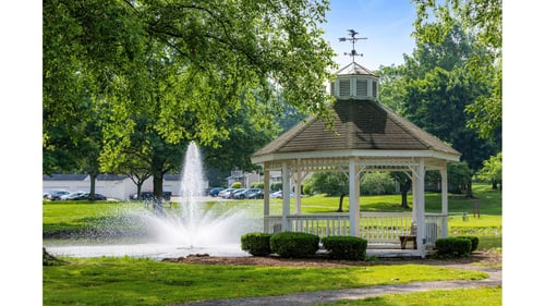 A serene park with a pond and a gazebo at Hunters Lake Apartments in Cuyahoga Falls, OH, 44221