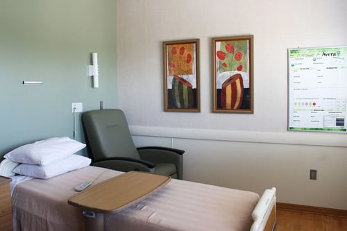 An alternate view of the postpartum room showing a white board and artwork on the walls.