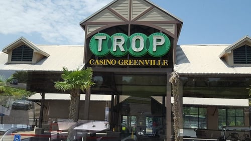 Trop Casino Greenville logo. Tropicana Greenville Casino - This spacious land-side casino is located in Historic Downtown Greenville, Mississippi. Tropicana Greenville is nestled in the heart of Greenville's Entertainment District and boasts beautiful views of Lake Ferguson. Our Las Vegas-style casino is home to hundreds of slot machines, exciting electronic table games, and much more.