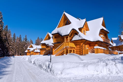 A cozy cabin in cold weather conditions, representing the need for fire and carbon monoxide safety during winter.