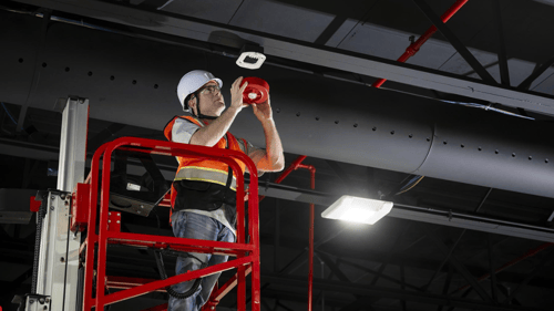 Quick Response Fire Protection employee installing a fire alarm