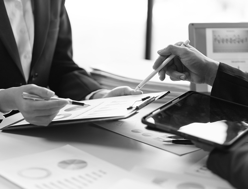 Close up of two people working on financial documents.