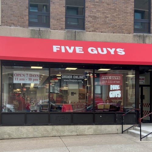 Exterior photograph of the Five Guys restaurant at 3714 Spruce Street in Philadelphia Pennsylvania.