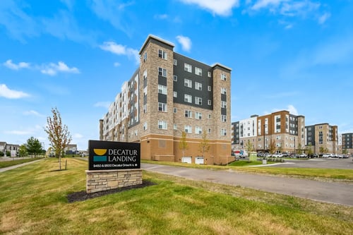 Exterior view of a modern building with landscaped surroundings at Decatur Landing in Brooklyn Park