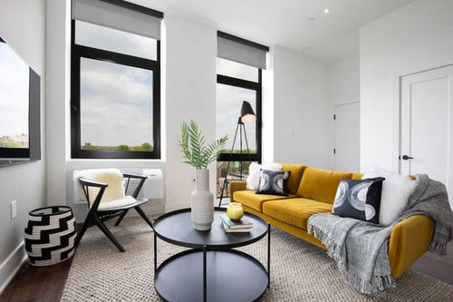 a living room with a yellow couch and a table at The Irvine, Philadelphia