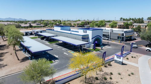 Aerial view of DASH Car Wash Olive Ave featuring our express wash tunnel, complimentary vacuum stations, and modern facility.