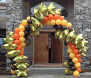 orange, black and gold star balloon arch over door area
