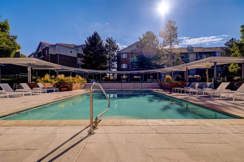 Swimming pool at Cierra Crest Apartments with lounge chairs and clear water.