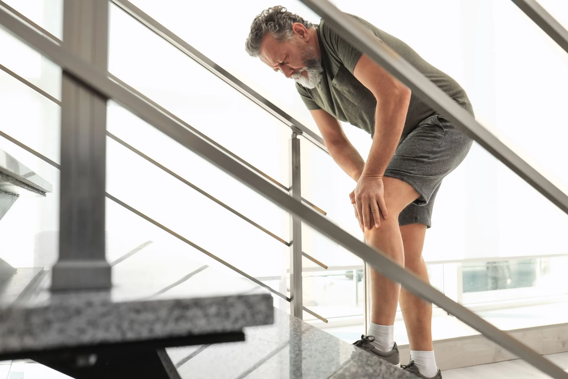 person struggling to walk up stairs with foot pain in the workplace