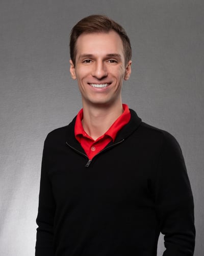 Agent Matt Arce standing and smiling wearing red button up under black zip up jacket