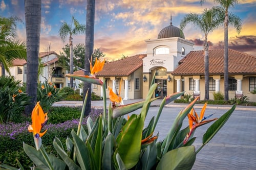 A building with a dome and palm trees in front at Toscana at Rancho Del Rey, Chula Vista, CA