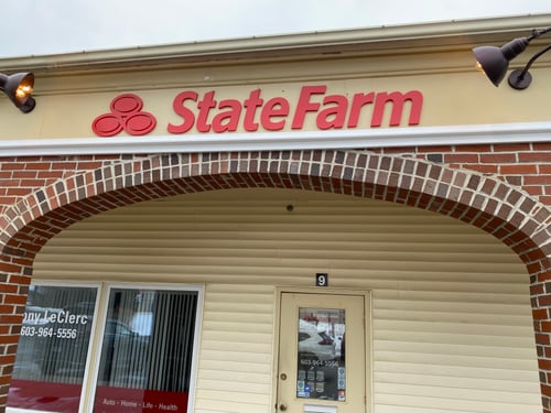 White and brick building with red State Farm sign