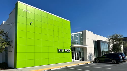 A contemporary RTG Patio storefront with bold green paneling, large glass windows, and an inviting entrance framed by greenery, located at 2970.