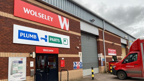 Entrance doors to the trade counter at Sowton Exeter with the Wolseley and Plumb and Parts  signage above, and the delivery lorry to the right