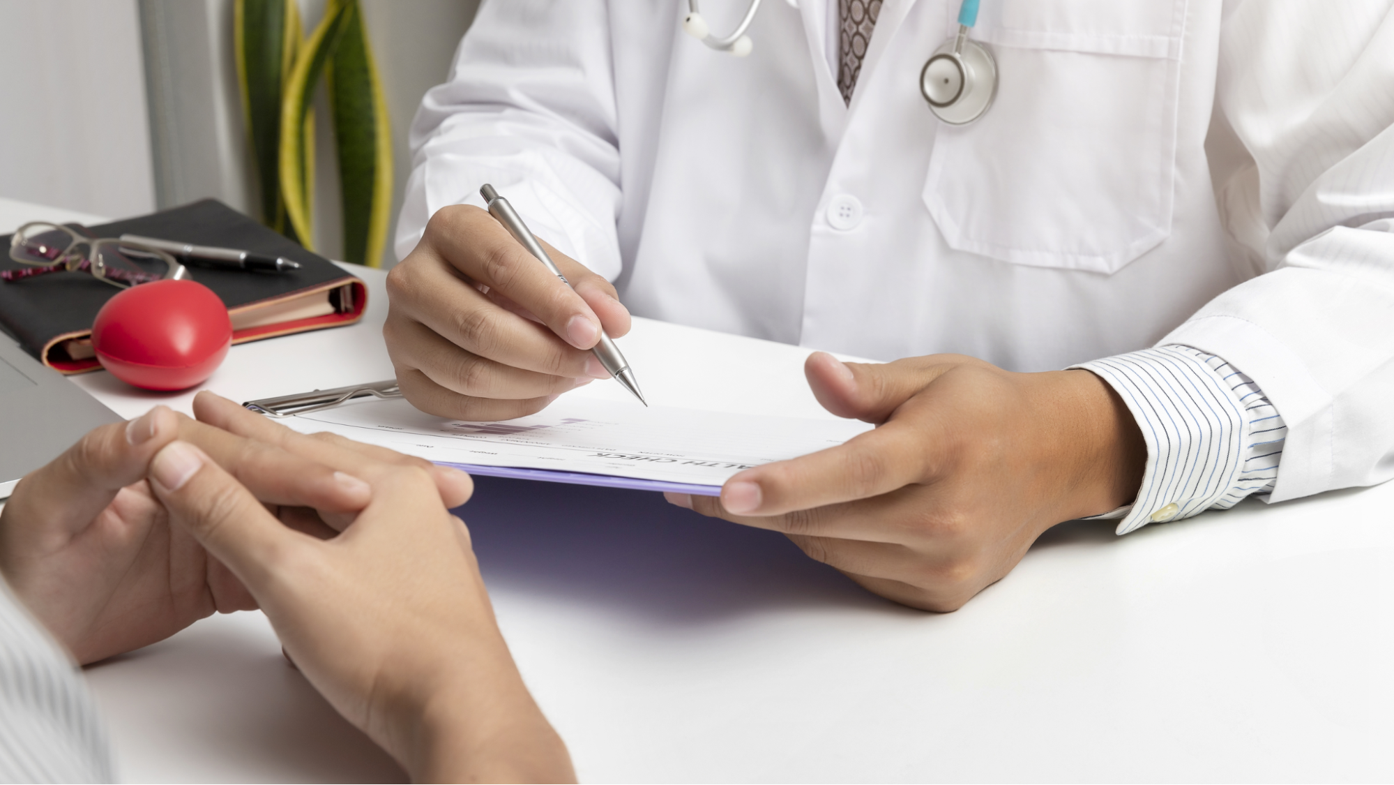 doctor writing notes across from patient