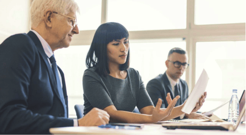 younger woman discussing paper with older man
