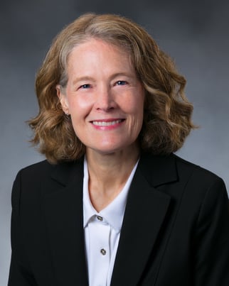 Shanna Case, MD smiling in front of a cool gray background.