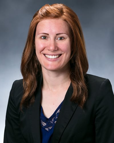 Dr. Evans smiling in front of a gray background.
