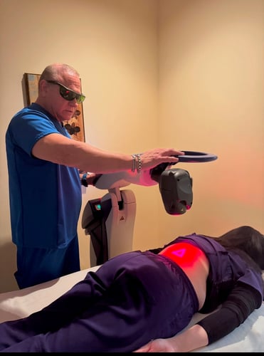 Dr. Michael A. Marks treating a patient's back with cold laser therapy