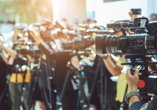 A row of press people with cameras and notebooks.