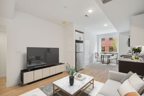 Open-concept living, kitchen, and dining area at The Gio Apartments with modern finishes and layout.