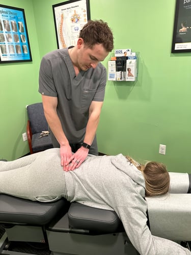 Dr. Matthew Wray performing a chiropractic adjustment on lower back.