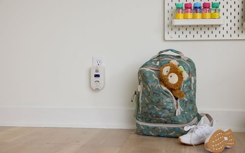 backpack sitting to the right of a Kidde Plugin Carbon Monoxide detector