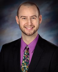 William Markes, PA-C smiling in front of a gray background.