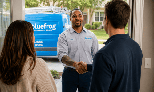 plumber shaking hands with home owner at front door