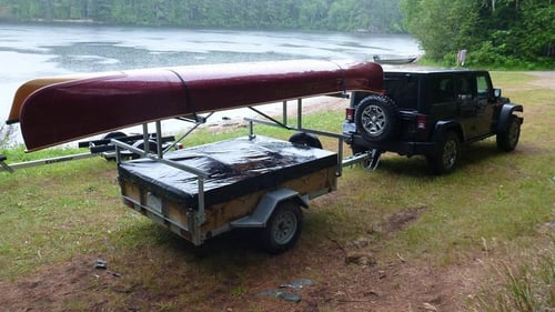 jeep with trailer hauling a canoe