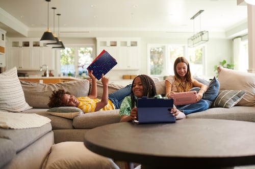 Three kids on tablets in family room