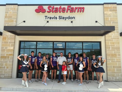 photo of football team and cheerleaders in front of the state farm office building