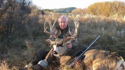 man in Montana holding buck up after being shot