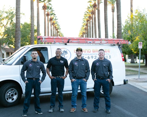 hvac employees standing in front of truck