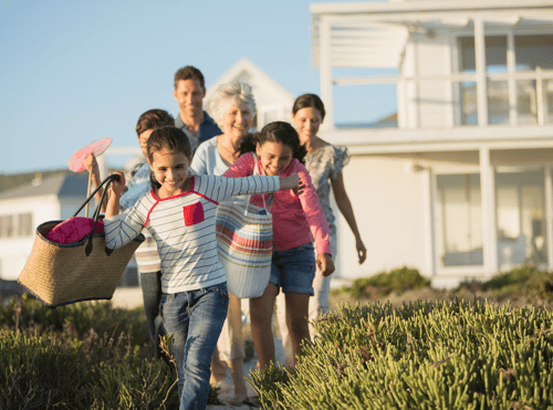 Multi-generational family walking to the beach.