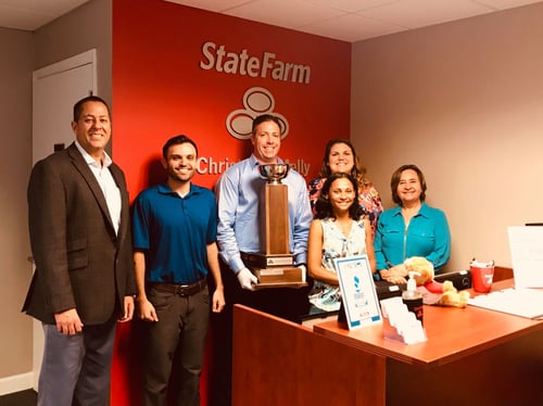Christopher and team members standing with award