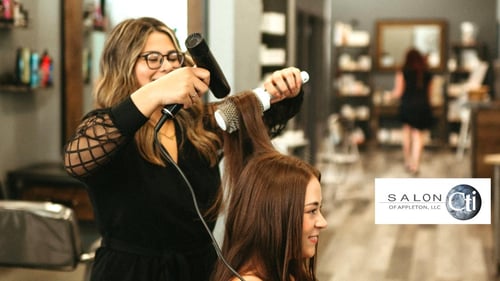 A professional stylist at Salon Cti of Appleton blow-drying a client’s hair in a modern, welcoming salon. Expert hair services including haircuts, hair coloring, balayage, and extensions in Appleton, WI.