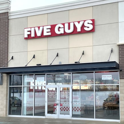 Exterior photograph of the entrance to the Five Guys restaurant at 2006 East Beltline Ave. NE in Grand Rapids Michigan.
