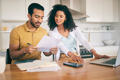 a couple working together on finances in the kitchen