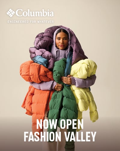 Woman holding puffer jackets.