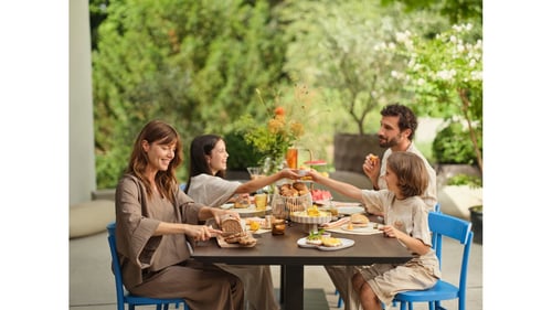 Eine Familie genießt ein entspanntes Frühstück im Freien. Frisch gebackenes Brot, Croissants und Brötchen stehen auf dem Tisch. Morgengold bringt regionale Backwaren frühmorgens an die Haustür – bequem, zuverlässig und mit höchster Qualität.