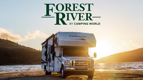 Class C RV parked beside a river with a sunset, the text "Forest RIver RV | Camping World" is above the RV