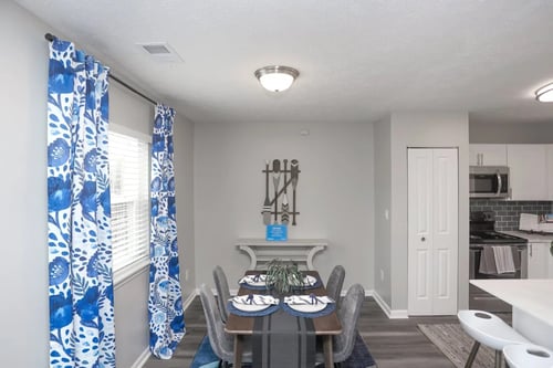 A dining room with a table set for two and a kitchen area in the background at Meridian Court South, Indianapolis, IN 46217