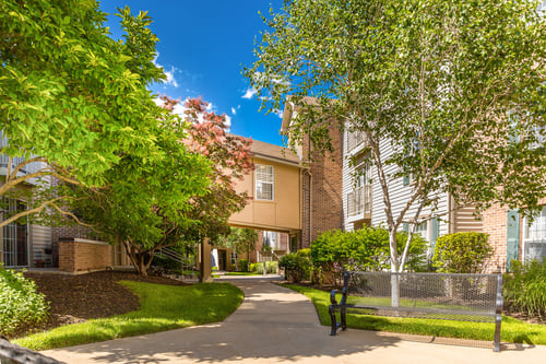 A residential area with a building and a tree at Prairie Commons - 55+ Senior Community Apartments, Lawrence, KS, 66049