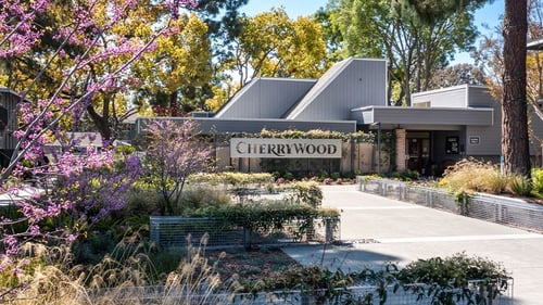Cherrywood sign in front of a building with trees and bushes Cherrywood Apartments in San Jose, CA 95118