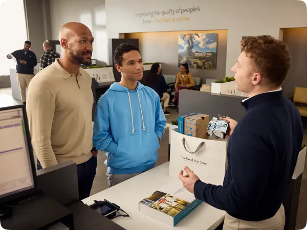 male good feet store employee helping customer at checkout