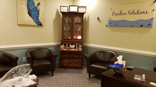 room with bookshelf and two chairs
